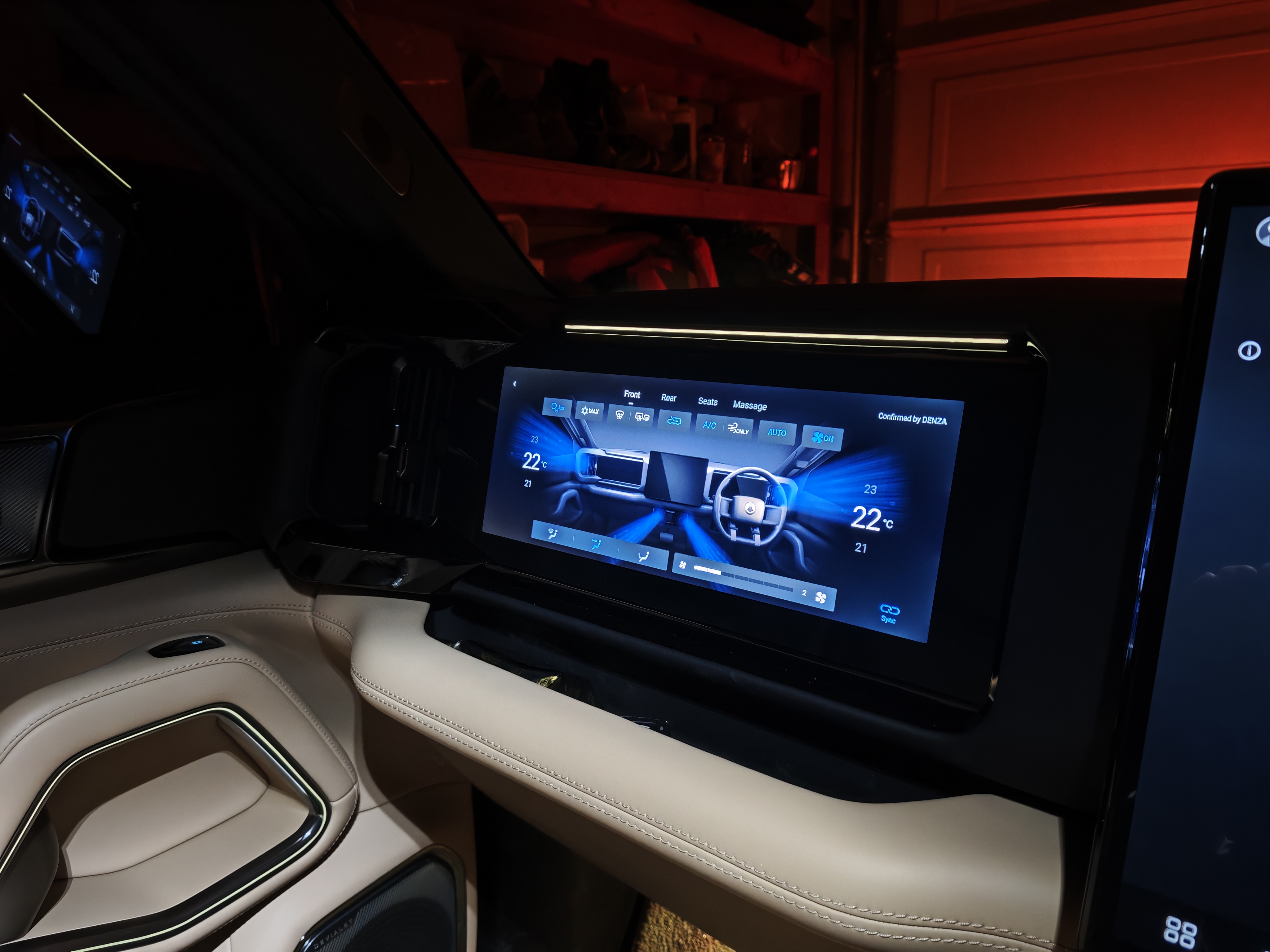 Pre-production passenger screen showing climate controls and Confirmed by DENZA